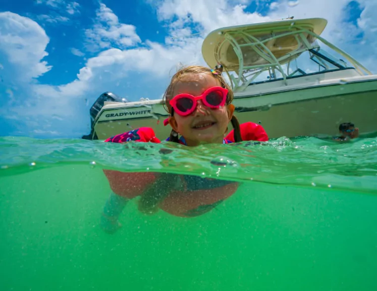 a young girl joyfully swims in the ocean, wearing goggles to explore the underwater world boat rental florida keys gallery boat image